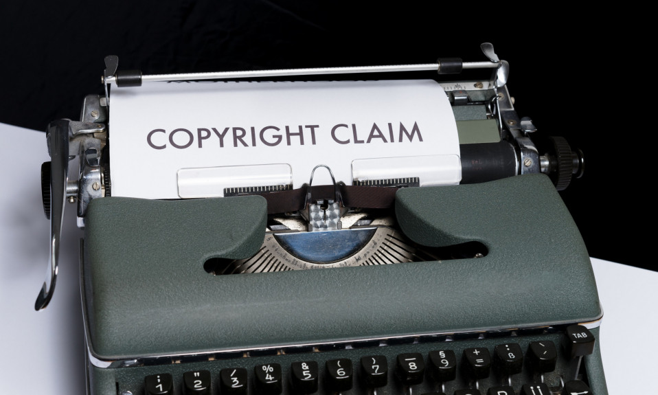 A printed paper on a typewriter with caption "Copyright Claim"